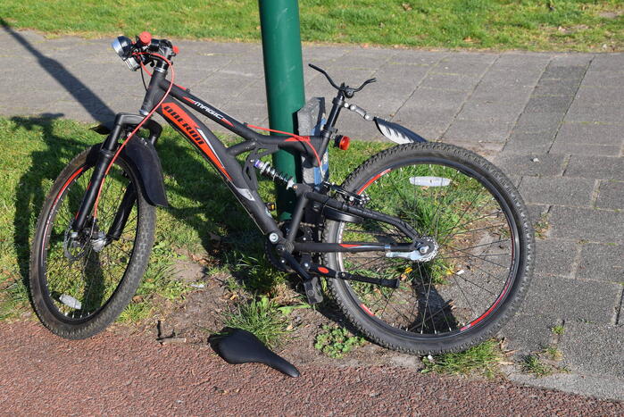 Jongeman op fiets vliegt over motorkap van auto