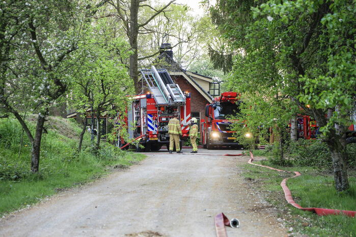 Vlammen slaan uit dak van vrijstaande woning