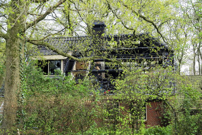 Vlammen slaan uit dak van vrijstaande woning