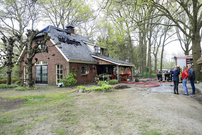 Vlammen slaan uit dak van vrijstaande woning