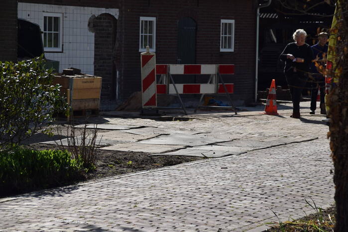 Persoon bekneld onder betonplaat