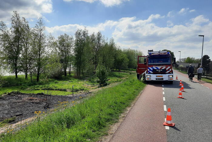 Stuk gras vlam gevat naast autoweg