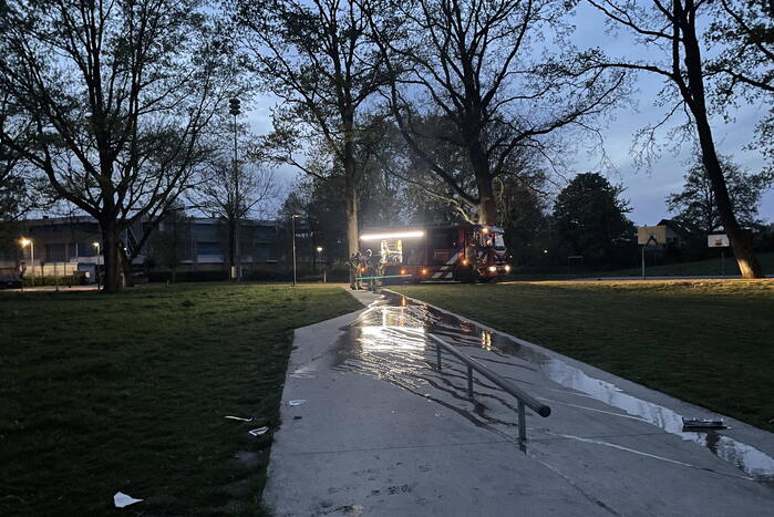 Brandweer blust brandende prullenbak