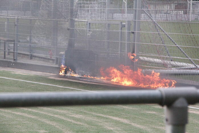 Vlammen bij brand naast sportveld