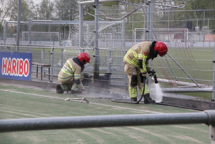Vlammen bij brand naast sportveld