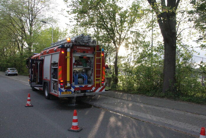 Vlammen bij brand naast sportveld