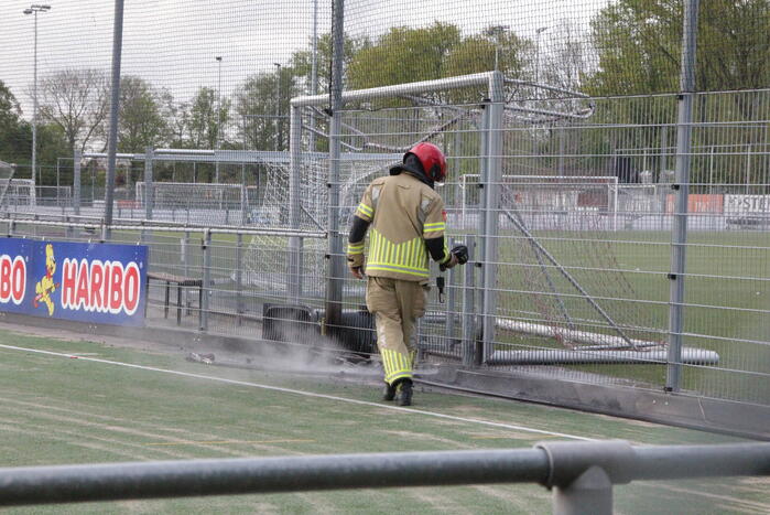 Vlammen bij brand naast sportveld