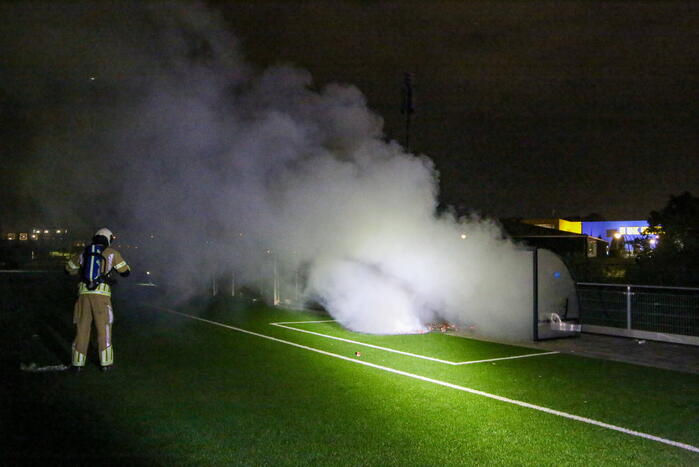 Vlammen op voetbalveld vanwege brand in afvalcontainer