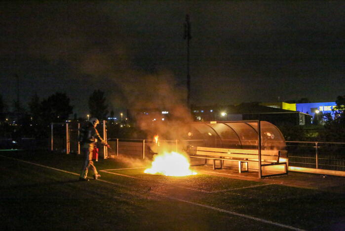 Vlammen op voetbalveld vanwege brand in afvalcontainer