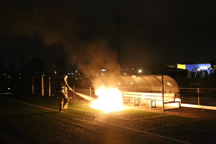 Vlammen op voetbalveld vanwege brand in afvalcontainer