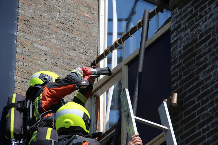 Brand op dak van woning boven woonwinkel Hema