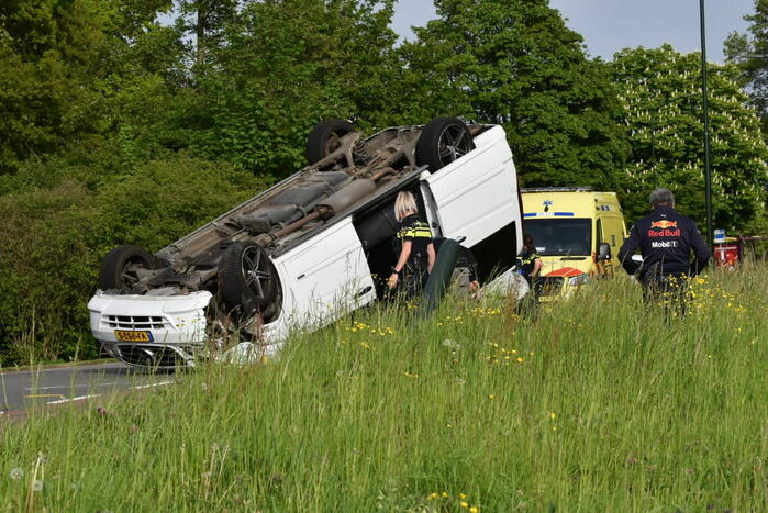 Bestelbus botst tegen paal en slaat over de kop