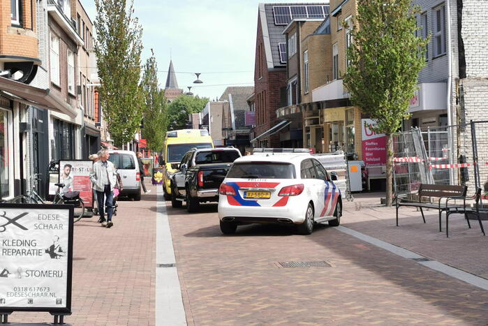 Voetganger aangereden door auto in winkelstraat