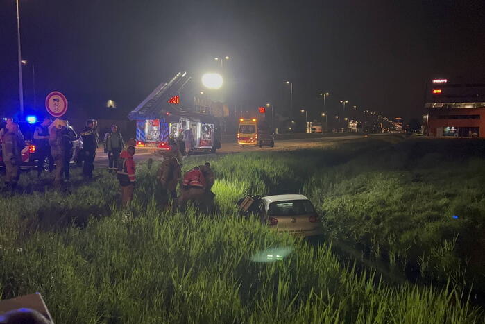 Brandweer redt persoon in voertuig uit sloot