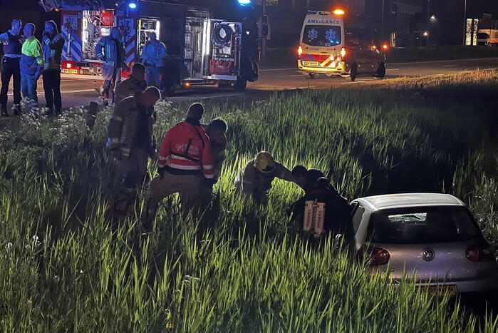 Brandweer redt persoon in voertuig uit sloot