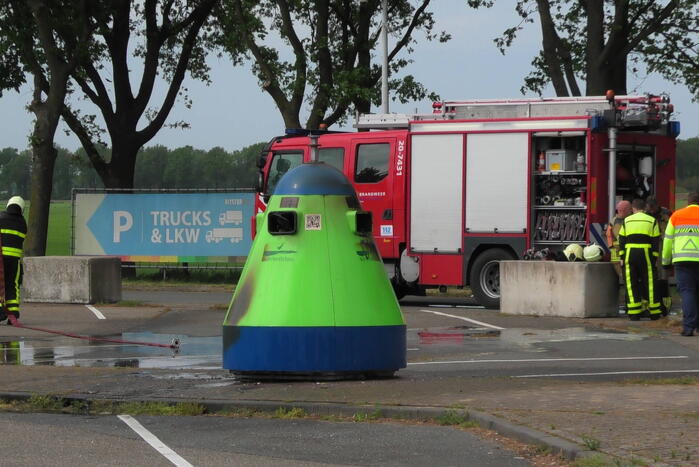 Restafvalcontainer op parkeerplaats langs snelweg vat vlam