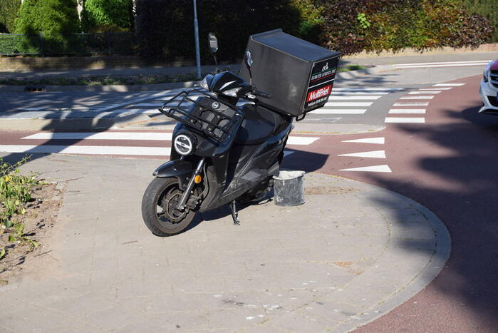 Maaltijdbezorger op scooter gaat hard onderuit
