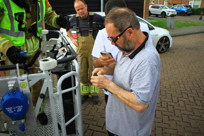 Brandweer bevrijdt zwaluw uit dakgoot