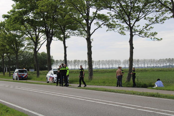 Personenauto raakt te water naast doorgaande weg
