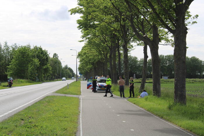 Personenauto raakt te water naast doorgaande weg
