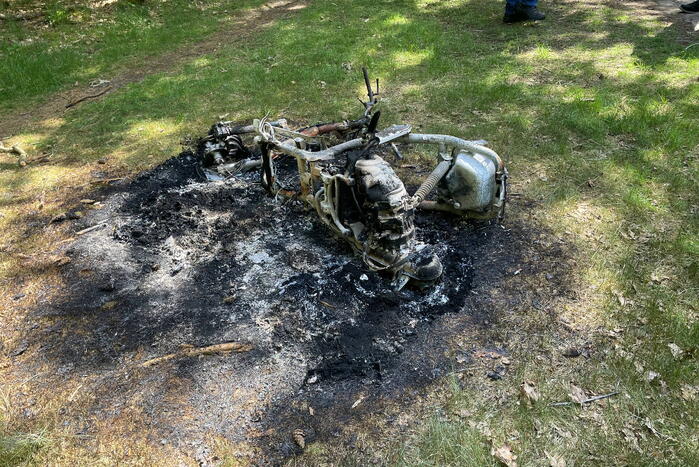 Onderzoek naar uitgebrande scooter in bosgebied