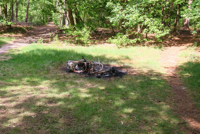 Onderzoek naar uitgebrande scooter in bosgebied
