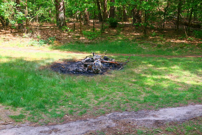 Onderzoek naar uitgebrande scooter in bosgebied