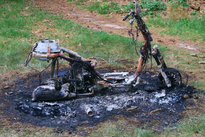 Onderzoek naar uitgebrande scooter in bosgebied