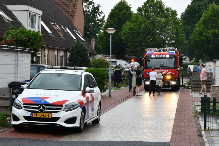 Veel rook uit zolderraam bij brand in woning
