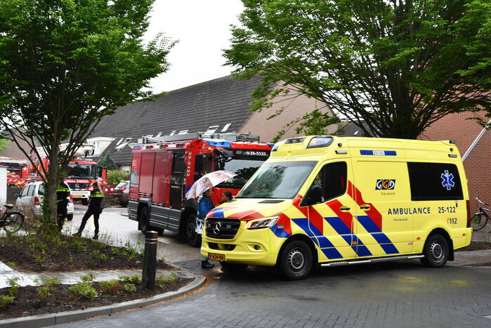 Veel rook uit zolderraam bij brand in woning