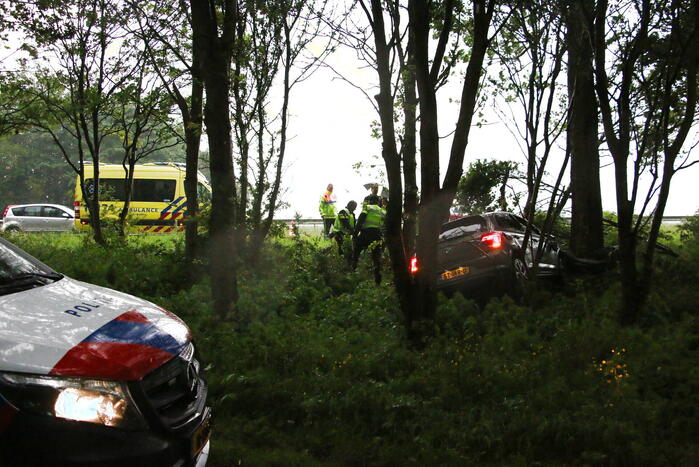 Automobilist schiet van de weg en belandt in bosschage