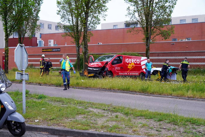 Bestuurder bestelbus bekneld na botsing tegen boom