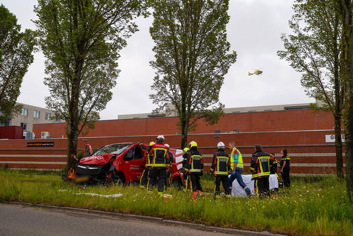 Bestuurder bestelbus bekneld na botsing tegen boom