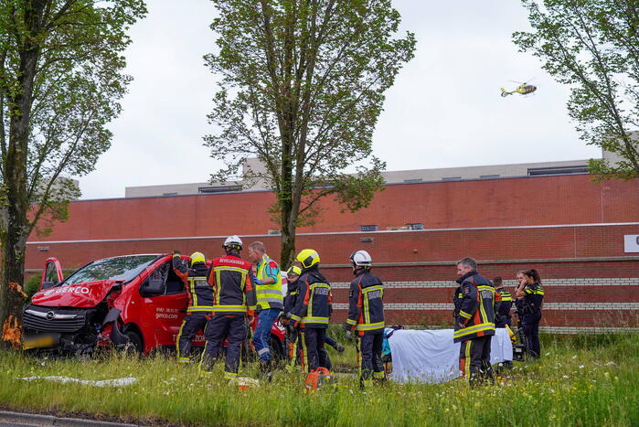 Bestuurder bestelbus bekneld na botsing tegen boom