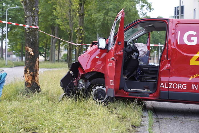 Bestuurder bestelbus bekneld na botsing tegen boom