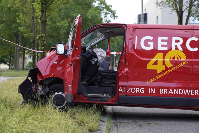 Bestuurder bestelbus bekneld na botsing tegen boom
