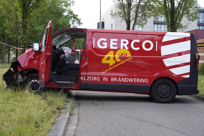 Bestuurder bestelbus bekneld na botsing tegen boom