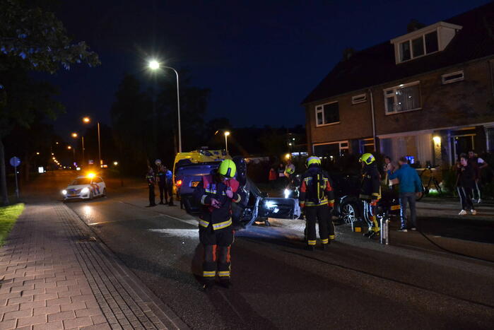 Auto op zijn kop na botsing met geparkeerde auto