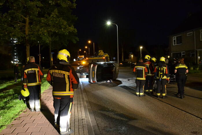 Auto op zijn kop na botsing met geparkeerde auto