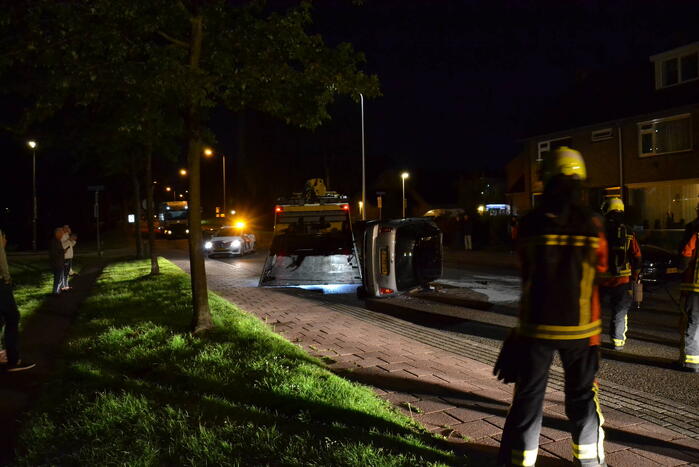 Auto op zijn kop na botsing met geparkeerde auto