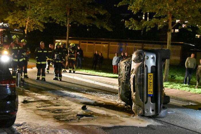 Auto op zijn kop na botsing met geparkeerde auto