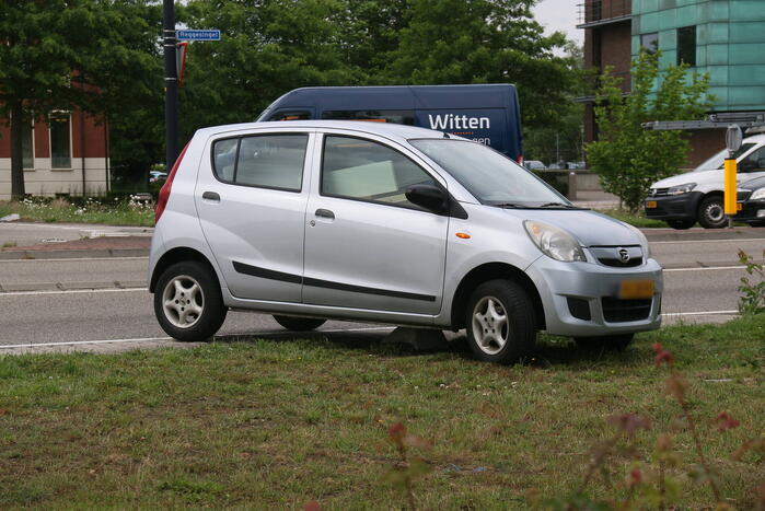 Auto zit vast op betonblok na verlaten van rotonde