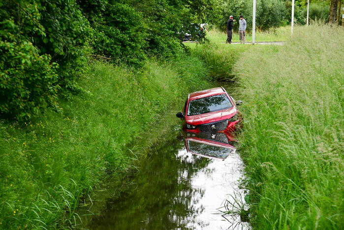 Auto rijdt over rotonde de sloot in