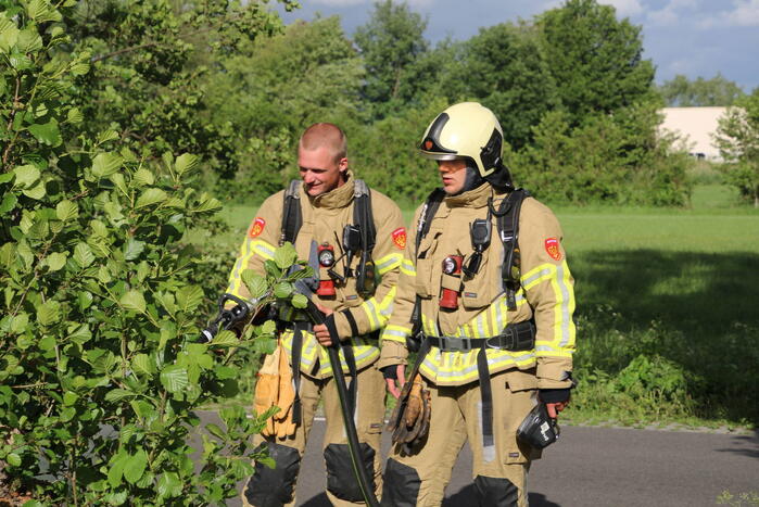 Weggegooid afval brand in bosjes