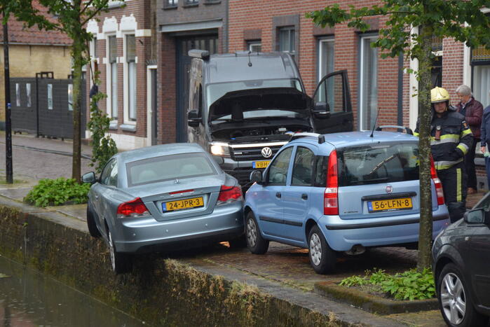 Auto bengelt op rand van gracht