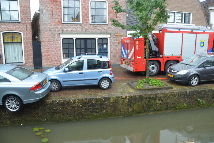 Auto bengelt op rand van gracht