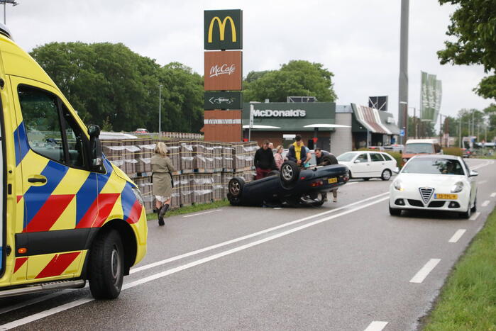 Auto over de kop bij botsing
