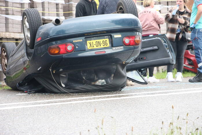 Auto over de kop bij botsing