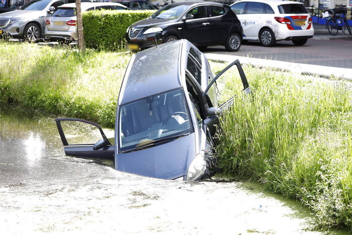 Geparkeerde auto belandt half in het water
