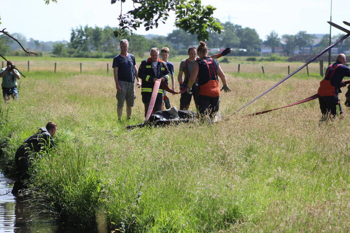 Een te water geraakte koe uit het water gehaald
